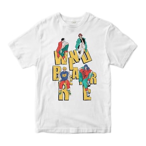 Puede incluir: Camiseta blanca con un diseño gráfico. El diseño presenta cuatro figuras con atuendos coloridos, colocadas alrededor del texto amarillo que dice "WIND BEAR". El diseño tiene una estética de dibujos animados.