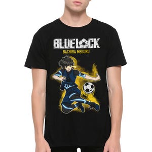 Może przedstawiać: Czarny T-shirt z grafiką piłkarza w niebiesko-żółtym stroju, kopiącego piłkę nożną. Na koszulce nadrukowany jest tekst "Blue Lock" i "Bachira Meguru".