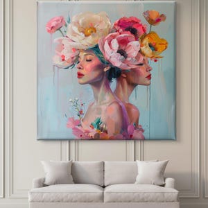 Puede incluir: Una pintura de dos mujeres con sus caras vueltas una de la otra. Ambas llevan una corona de flores rosas, blancas y amarillas. El fondo es azul claro.