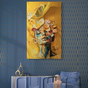 Op de afbeelding: Een schilderij van een vrouwen gezicht met bloemen die haar ogen bedekken. De achtergrond is geel en het gezicht van de vrouw is geschilderd in een blauw en groen kleurenpalet.