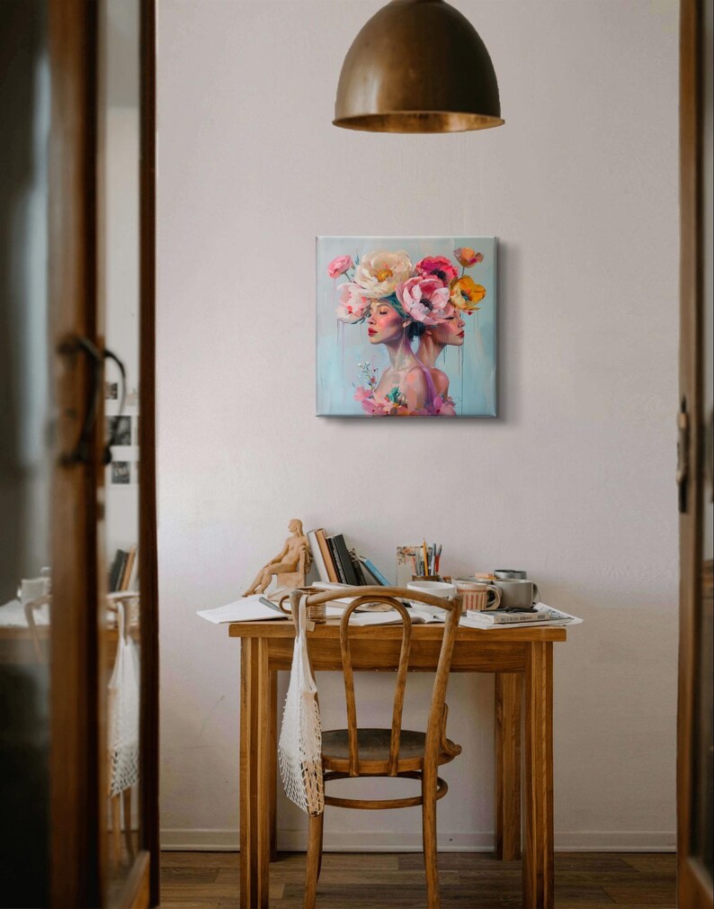 Puede incluir: Una pintura de dos mujeres con flores en la cabeza. Las mujeres miran hacia adelante y tienen los ojos cerrados. Las flores son rosas, blancas y amarillas. El fondo es azul claro.