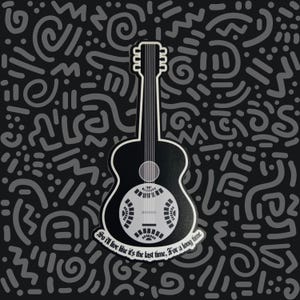 May include: A black and white sticker featuring a resonator guitar with a circular metal plate. The text "So I'll live like it's the last time, For a long time" is printed in a white banner at the base of the guitar body against a dark background.