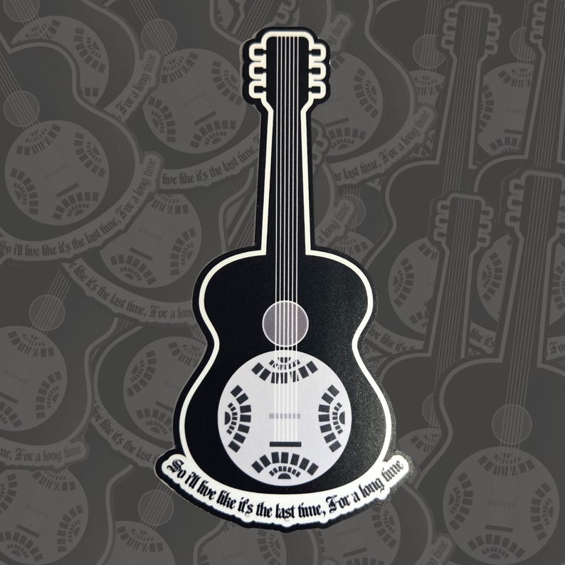 May include: A black and white sticker featuring a resonator guitar design. The guitar has a distinctive round sound hole and a stylized appearance. The text "So I'll live like it's the last time, For a long time" is written on the bottom.