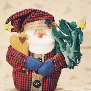 May include: A red and black plaid Santa Claus doll holding a heart-shaped ornament and a green fabric Christmas tree.