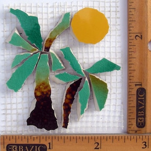 May include: Mosaic art piece depicting a palm tree and a yellow sun. The palm tree has green leaves and a brown trunk. The mosaic is made of broken tiles and is on a white mesh backing. A wooden ruler is in the image.