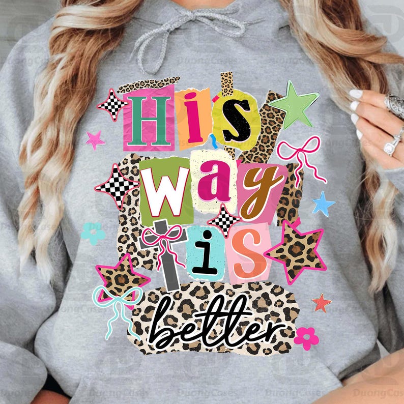 May include: A gray hoodie with a colorful graphic that reads "His Way is Better." The design features a collage of letters, stars, bows, and leopard print accents in various colors, including pink, green, and orange.