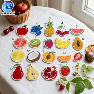 Puede incluir: Una colección de veinte parches bordados de frutas dispuestos sobre una superficie de tela blanca, numerados del 1 al 20. Los diseños incluyen una manzana, arándanos, piña, cerezas, sandía, pomelo, kiwi, frambuesa, plátanos, papaya, limón, coco, melocotón, naranja, fresa, pera, pera cortada, granada y fresa.