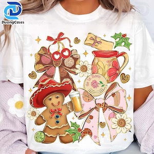 May include: White t-shirt featuring a festive design with a gingerbread man wearing a red hat, bows, flowers, and a mug. The design includes a glass of beverage, holly, and a decorative element with the text "Se La Rosa".