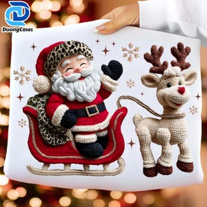 May include: A white pillow featuring a crocheted Santa Claus in a red suit and a reindeer. Santa is in a red sleigh with a leopard print bag. The reindeer has brown antlers and a red nose. The pillow has snowflake and star accents.