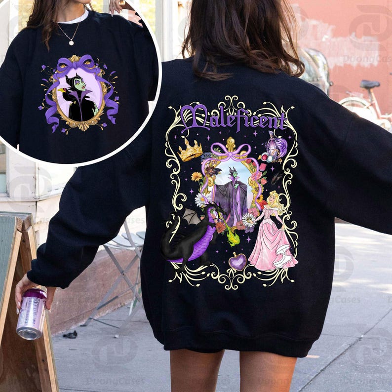 Puede incluir: Sudadera negra con una imagen enmarcada de Mal&eacute;fica en la parte delantera y trasera. El dise&ntilde;o trasero incluye la palabra "Mal&eacute;fica" en escritura p&uacute;rpura, una corona, un drag&oacute;n y una princesa con un vestido rosa. El dise&ntilde;o frontal es un primer plano de Mal&eacute;fica en un marco p&uacute;rpura.