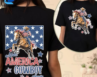 May include: Black t-shirt featuring a graphic of a cowboy riding a horse, surrounded by stars. The text "Make America Cowboy Again" is displayed in red and blue. The design is on the front and back of the shirt.