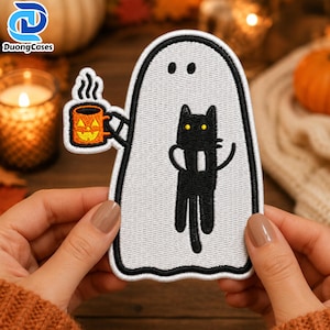 May include: An embroidered patch featuring a white ghost with a black outline. The ghost holds an orange jack-o'-lantern mug with steam rising from it and carries a black cat with yellow eyes on its front. The design is flat and stitched.