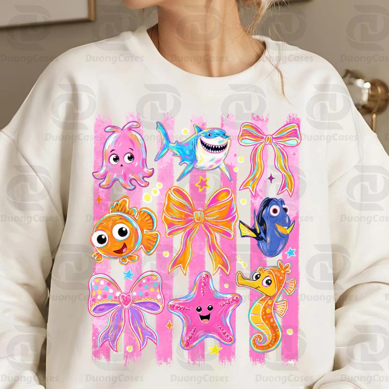 May include: White sweatshirt featuring colorful cartoon sea creatures and bows on a pink striped background. The design includes an octopus, shark, fish, seahorse, starfish, and bows in various colors. The sweatshirt has a crew neck.