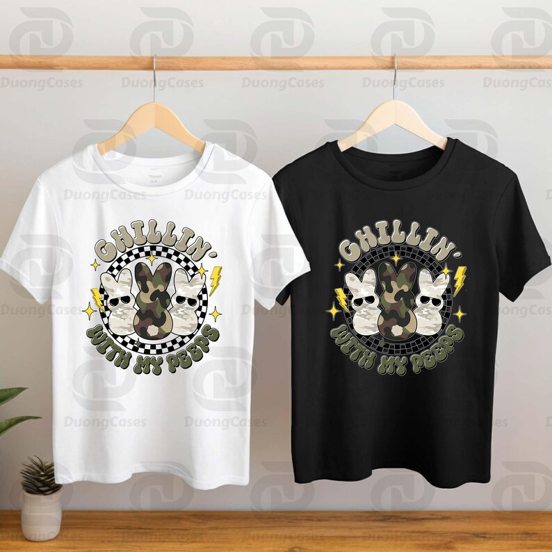 May include: White and black t-shirts with a graphic design featuring three cartoon bunnies wearing sunglasses, a camouflage bunny, and the text "CHILLIN WITH MY PEEPS". The design is in a circular frame with lightning bolts.
