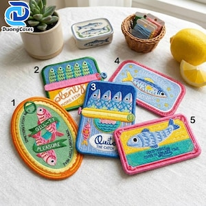 May include: Five embroidered patches featuring fish themes. Patch 1 is oval with pink fish and text. Patches 2, 3, 4, and 5 are rectangular with various fish illustrations, colorful borders, and text including 'plenty more fish', 'Quite the catch', 'fin-tastic', and 'good things come in small fine'.