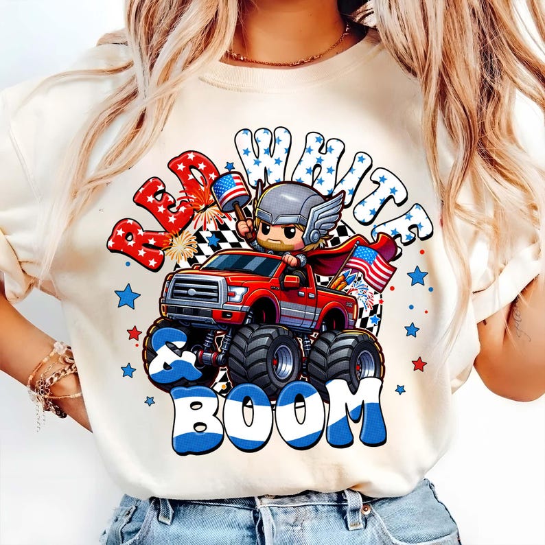 Puede incluir: Sudadera de color crema con un dise&ntilde;o gr&aacute;fico que presenta un cami&oacute;n monstruo rojo conducido por un personaje de dibujos animados. El dise&ntilde;o incluye las palabras "Red, White & Boom" en rojo, blanco y azul, con estrellas y banderas. El cami&oacute;n tiene neum&aacute;ticos negros grandes.