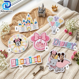 May include: A collection of seven embroidered patches featuring Disney-themed designs including a castle, balloons, a Ferris wheel with Minnie Mouse, a pink bow with a castle, the word Disneyland, the word Disney, and Dumbo with Mickey and Minnie.