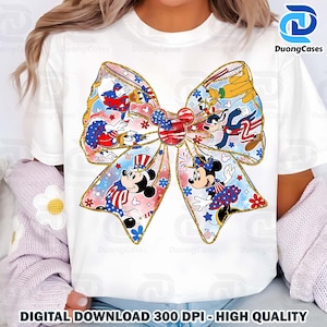 K&ouml;nnte beinhalten: Ein wei&szlig;es T-Shirt mit einem bunten Schleifendesign, das Mickey Mouse und andere Disney-Charaktere in patriotischer rot-wei&szlig;-blauer Kleidung zeigt. Die Schleife ist mit goldenem Glitzer und Sternen verziert.