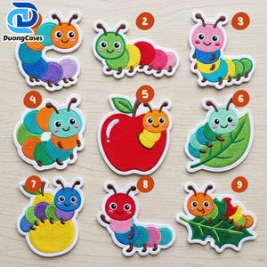 May include: Nine embroidered patches featuring colorful cartoon caterpillars in various poses, including some on apples and leaves. Each patch is numbered one through nine, showcasing vibrant segments in shades of red, blue, green, yellow, orange, and purple.