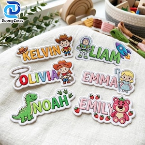 May include: Six embroidered name patches featuring cartoon characters and themes. The patches display the names KELVIN, LIAM, OLIVIA, EMMA, NOAH, and EMILY, each accompanied by colorful character illustrations including a cowboy, space ranger, cowgirl, shepherdess, dinosaur, and a pink bear.
