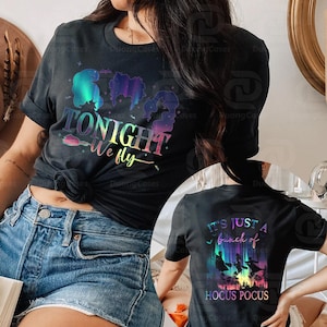 May include: Black t-shirt with a colourful graphic featuring silhouettes and the text "TONIGHT we fly." The back of the shirt has the text "IT'S JUST A bunch of HOCUS POCUS" with silhouettes of witches.