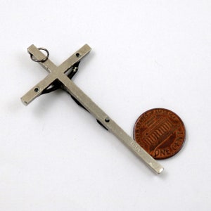 Puede incluir: Crucifijo de metal plateado con una peque&ntilde;a figura de Jesucristo. El crucifijo es aproximadamente del tama&ntilde;o de una moneda de un c&eacute;ntimo de euro.