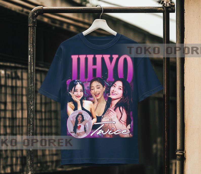Puede incluir: Camiseta azul marino con un gr&aacute;fico de tres mujeres y el nombre "JIHYO" en morado. Tambi&eacute;n es visible la palabra "Twice". La camiseta est&aacute; colgada en un perchero de metal.