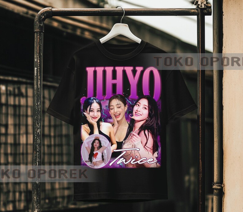 Puede incluir: Camiseta negra con un gr&aacute;fico de tres mujeres, el texto "JIHYO" en morado y "Twice" en blanco. Una imagen m&aacute;s peque&ntilde;a de una mujer est&aacute; en un c&iacute;rculo. La camiseta est&aacute; colgada en un perchero de metal.
