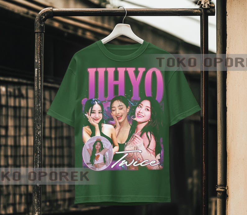 Puede incluir: Camiseta verde con un dise&ntilde;o gr&aacute;fico retro de tres mujeres y la palabra "Twice". La camiseta tambi&eacute;n presenta el nombre "IHYO" en rosa. La camiseta est&aacute; colgada en un perchero de metal.