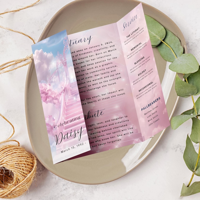 May include: A pink and white tri-fold funeral program with a photo of a stairway to heaven and the words "Celebrating Daisy" on the front. The program includes the dates "January 8, 2024" and "March 15, 1992" and the words "Service", "The Liturgy", "Memorial", "Blessing", "Eulogy", "Recessional", and "Pallbearers".