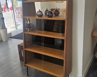 Libreria espositiva modernista con ante scorrevoli in vetro.