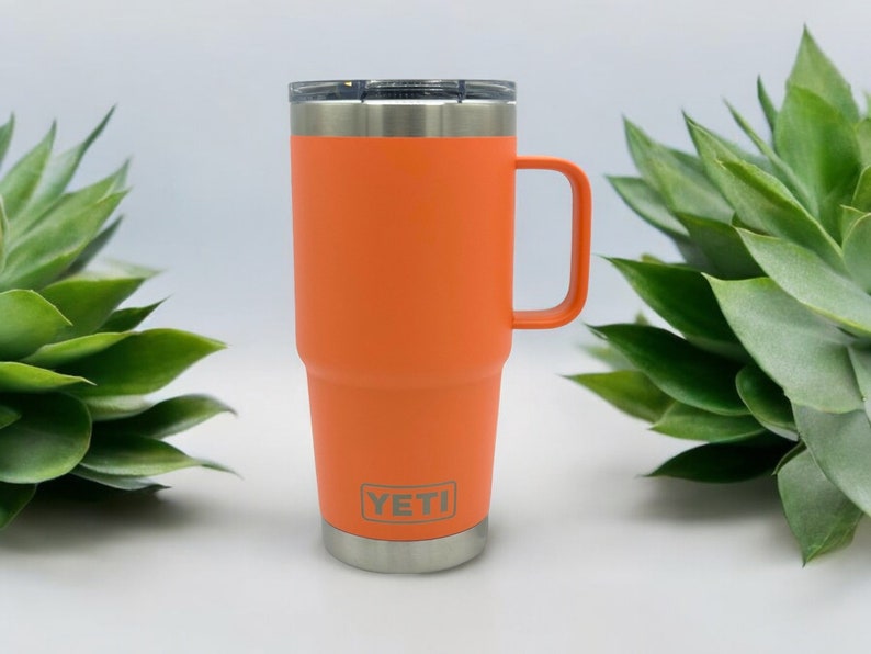 May include: Orange YETI Rambler 30 oz. travel mug with a stainless steel lid and handle.