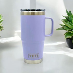 May include: A purple YETI Rambler travel mug with a stainless steel lid and handle. The mug has a YETI logo on the side.