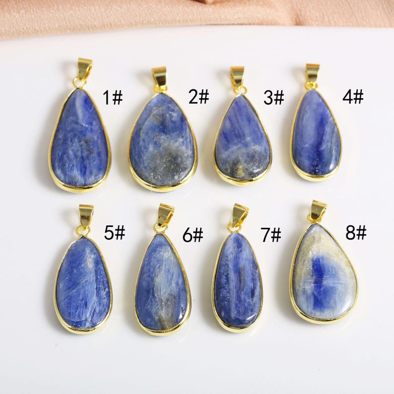 May include: Eight gold-plated pendants with blue gemstone drops. Each pendant is numbered 1 through 8.
