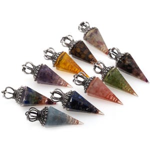 May include: Set of ten crystal point pendants with silver crown tops. The pendants are made of various crystals, including amethyst, citrine, rose quartz, and lapis lazuli.