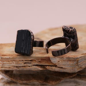 May include: Two adjustable rings with black tourmaline stones set in copper.