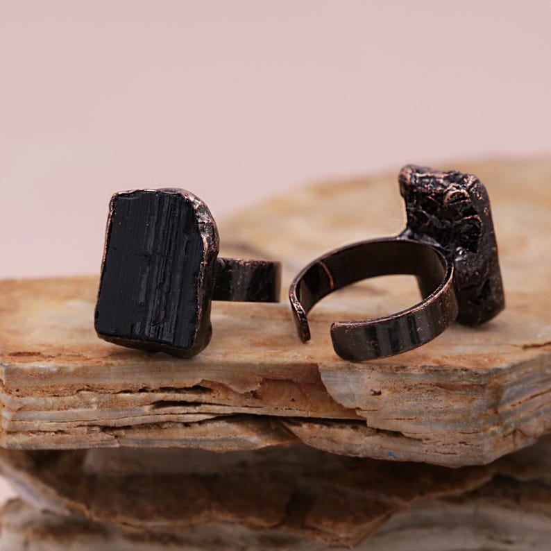 May include: Two adjustable rings with black tourmaline stones set in copper.