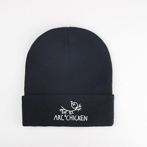 May include: Black beanie with a white embroidered design of a bird with the text "ARC' CHICKEN" underneath.