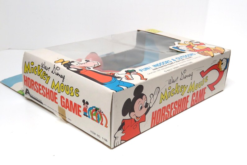 May include: A vintage Walt Disney Mickey Mouse Horseshoe Game box in blue, red and white. The box features illustrations of Mickey Mouse, Goofy and Donald Duck. The text on the box reads "Walt Disney Mickey Mouse Horseshoe Game" and "Fun Indoors & Outdoors".