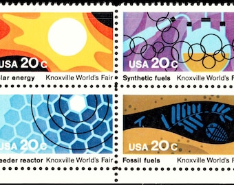 May include: A block of four postage stamps from the Knoxville World's Fair, each marked USA 20c. The designs feature solar energy with a sun, synthetic fuels with laboratory glassware, a breeder reactor with a blue honeycomb, and fossil fuels with a fish skeleton.