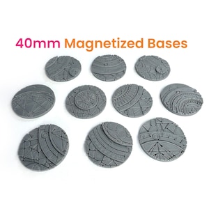 May include: A collection of ten gray, textured, 40mm magnetized bases. Each base features a unique design with geometric patterns and lines. The text "40mm Magnetized Bases" is displayed in orange and pink.