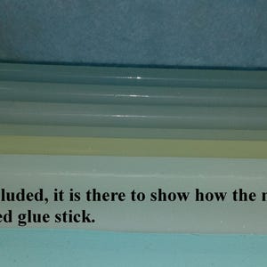 May include: A white silicone mold for making glue sticks. The mold has four slots and is shown with a glue stick inside one of the slots. "Glue stick is NOT included, it is there to show how the mold compares to a full size manufactured glue stick."