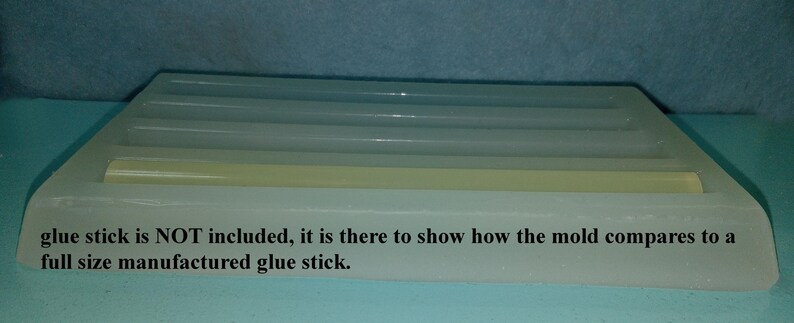 May include: A white silicone mold for making glue sticks. The mold has four slots and is shown with a glue stick inside one of the slots. "Glue stick is NOT included, it is there to show how the mold compares to a full size manufactured glue stick."