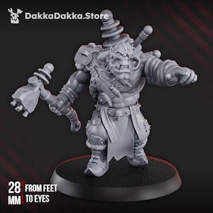 Puede incluir: Una figura miniatura de orco gris sin pintar sobre una base circular. El orco sostiene un martillo grande, lleva un cinturón con una hebilla de calavera y tiene una oreja puntiaguda. El texto dice DakkaDakka.Store y 28 mm de pies a ojos.
