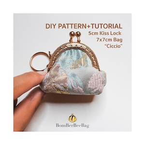 May include: A small, patterned coin purse with a kiss lock closure. The purse is approximately 2 inches wide and 2.75 inches tall. The fabric has a floral design in shades of blue, pink, and gold. The text "DIY PATTERN+TUTORIAL" is visible.