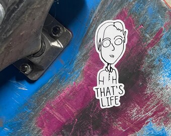 May include: A blue and pink skateboard with a black truck and white wheels. A sticker of a cartoon person with the text "Ah That's Life" is on the board.