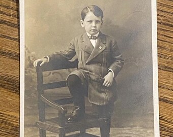 Vintage Foto Postkarte RPPC Junge mit Fuß auf Stuhl AZO 1907 - 1918 Ungebraucht