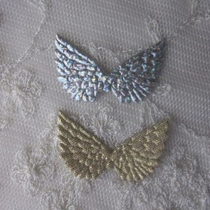 May include: Two pairs of decorative angel wings. One pair is silver with iridescent glitter and the other pair is gold with a shimmery finish.