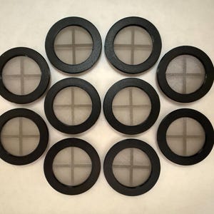 May include: Ten black round filter discs with a white mesh center. Each disc has a cross-shaped pattern in the mesh.