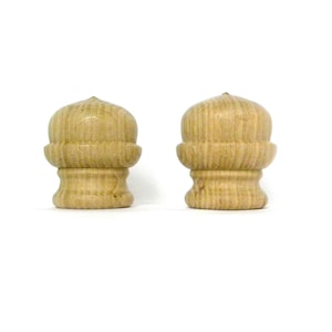 以下が含まれることがあります： 丸みを帯びたトップと溝のあるデザインの、木製のフィニアルが2つ。フィニアルは薄い茶色です。